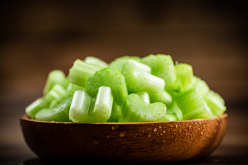 A wooden plate with a piece of celery. 