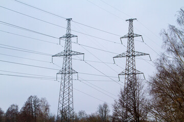 New large mast of an air power line close up, high voltage electricity pylon with thick wires and insulators, blue sky on background. Traditional energy. Electric power concept.
