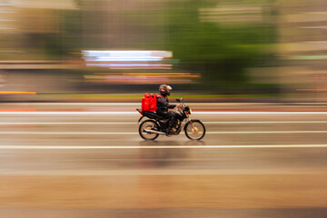 Obraz na płótnie Canvas Food delivery boy riding a bike in the city