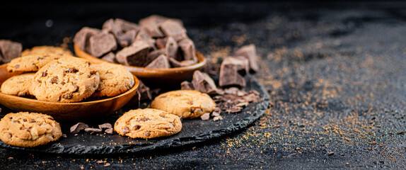 Cookies with pieces of milk chocolate on a stone board. 