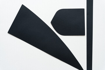 three black paper shapes isolated on blank paper