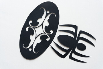 black paper spider glyph or dingbat cutout and ornamental shape in an oval form