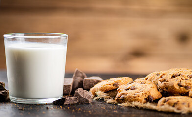 Cookies with pieces of milk chocolate with a glass of milk. 