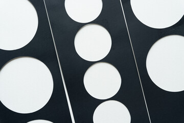 background composed of black paper stencil with circle cutouts on white
