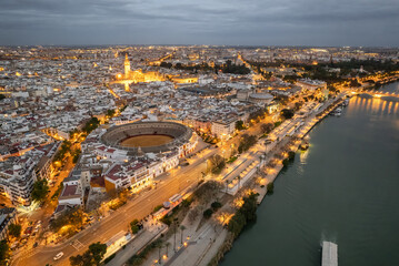 Seville old town with corrida arena, Cathedral and Guadalquivir riverfront at night, Andalusia region, Spain