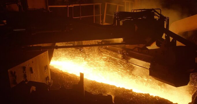 Metal casting process in metallurgical plant. Liquid metal pouring into molds