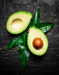 Cut ripe avocado with leaves. 