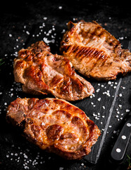 Delicious grilled pork steak on a stone board. 