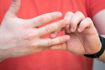 Man takes off a wedding ring. A man wants to end his relationship with his wife