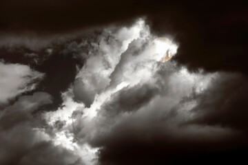 Naklejka na ściany i meble Full Moon half-hidden in thick clouds