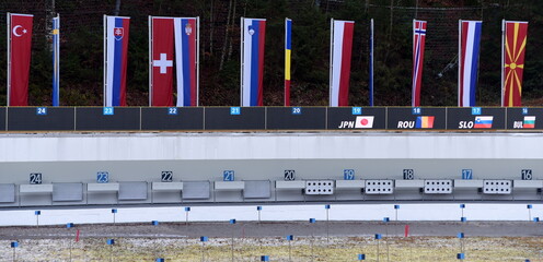 Schießstand mit Schießscheiben unter Fahnen der teilnehmenden Länder