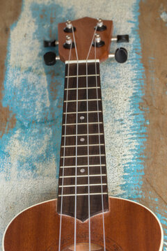 Ukulele, a small Hawaiian guitar, on rustic board