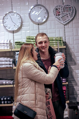 Beautiful couple with shopping bags is talking and smiling while doing shopping in the mall. young couple shopping before the holiday.