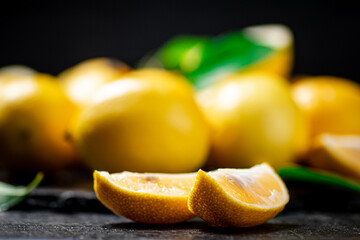 Fragrant lemons with leaves on the table. 