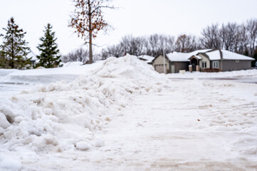 Snowbank at the end of a driveway left after city snowplows cleared a street.