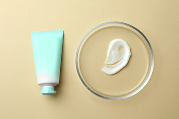 Petri dish and cosmetic product on beige background, flat lay