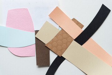 blue, pink, brown, and black abstract paper shapes (some geometric) on blank paper