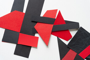 black and red abstract paper shapes (some geometric) on blank paper