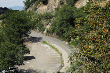 Road and parking lots with painted markings on asphalt near mountains outdoors