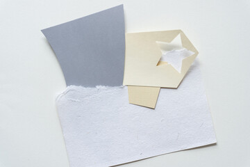 star cutout and mostly gray and white abstract paper shapes (some geometric) on blank paper