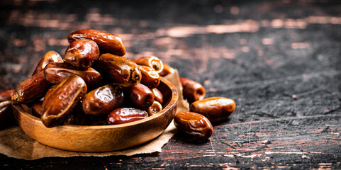 Delicious dates on a wooden plate. 