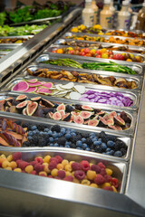 Variety of colorful fruits, berries, and vegetables at a salad bar. Berries, figs, and radishes.