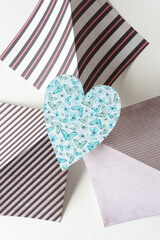 Obraz premium simple blue heart with butterflies on folded scrapbook paper sheets