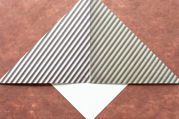 folded scrapbook paper with decorative striped pattern on brown tissue paper