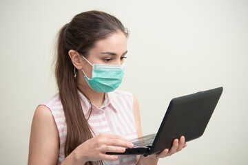 Coronavirus. Young business woman working from home wearing protective mask, Online training education and freelance work.. Working from home