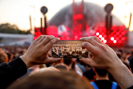 Making photos and videos of the outdoor summer concert via smartphone.