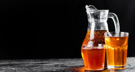 Apple juice in a jug and glasses with air bubbles. 