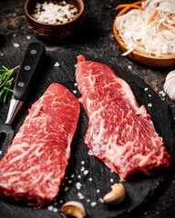 Raw steak with rosemary and spices on the table. 