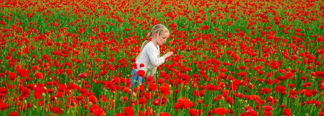Spring family holidays on nature. Poppies meadow with poppys flowers. Beautiful child girl walking...