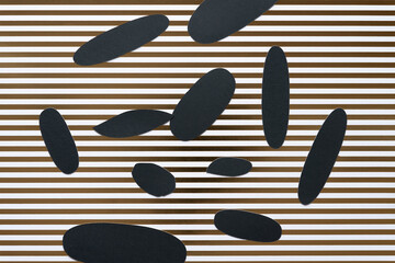 various grungy cut paper shapes (mostly oval or ovoid) on scrapbook paper with gold stripes