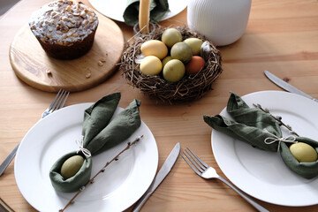 Festive Easter table setting with Easter bunny made of linen napkin and egg