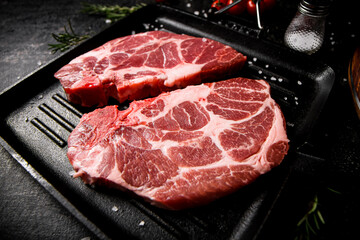 Raw pork steak in a frying pan. 