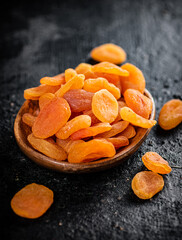 Dried apricots in a wooden plate on the table. 