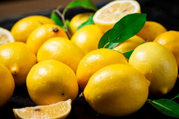 Fragrant lemons with leaves on the table. 