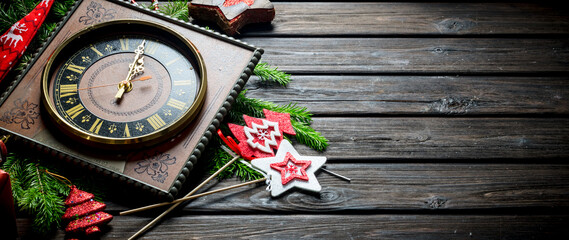 Old clock with Christmas decorations and fir branches.