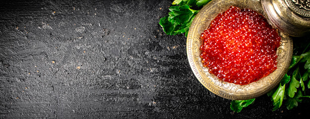Full bowl of red caviar on the table. 