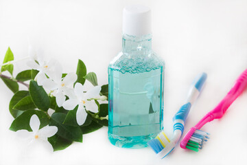 mouthwash, toothbrush health care for oral cavity with jasmine flowers arrangement flat lay style on background white 