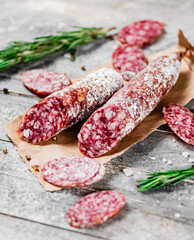 Pieces of salami sausage with sprigs of rosemary. 