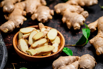 Fototapeta premium Pieces of fresh ginger on a wooden plate. 
