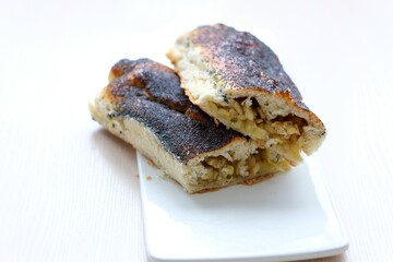 strudel with apples sprinkled with poppy seeds on white flat plate and light background no other ingredients clean space for your text delicious food cooking homemade baking products healthy food