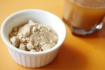 mixing brewers yeast flakes in a glass of water 