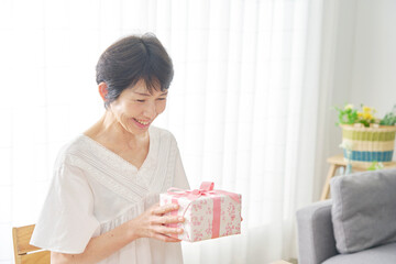 プレゼントを持って喜ぶ中年女性