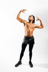 Fototapeta premium Young athletic Black man flexing his muscles on white background in an indoor studio