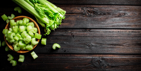 Sliced fresh celery. On a dark wooden background.