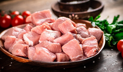 Raw pork sliced on a plate with tomatoes. 