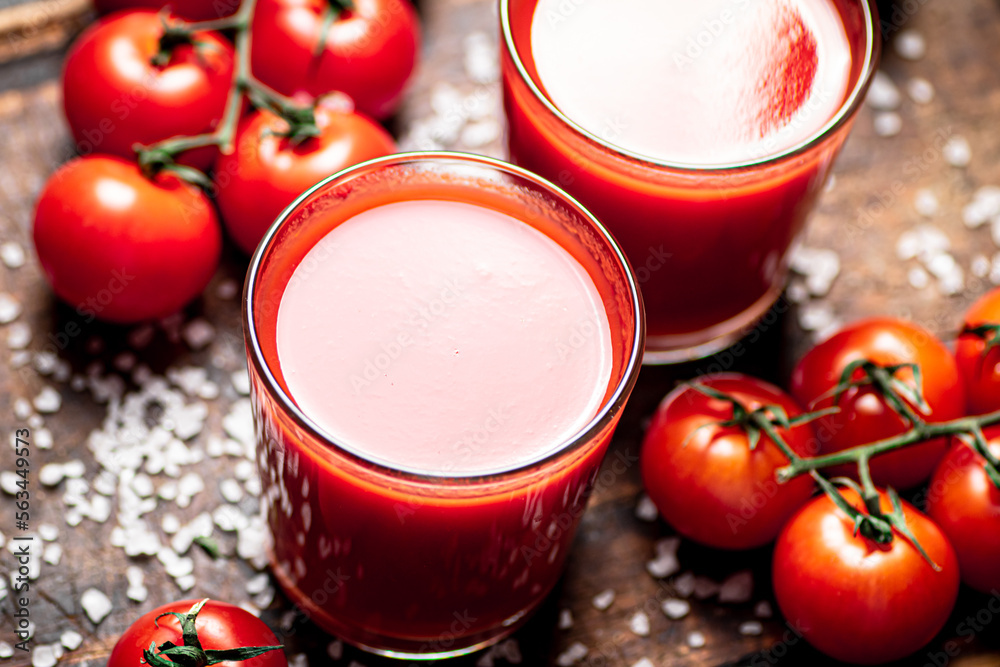 Poster Tomato juice in a glass with pieces of salt. 